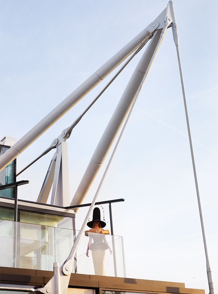 model wearing top hat on roof at The Emory, with architectural sales creating a striking image.