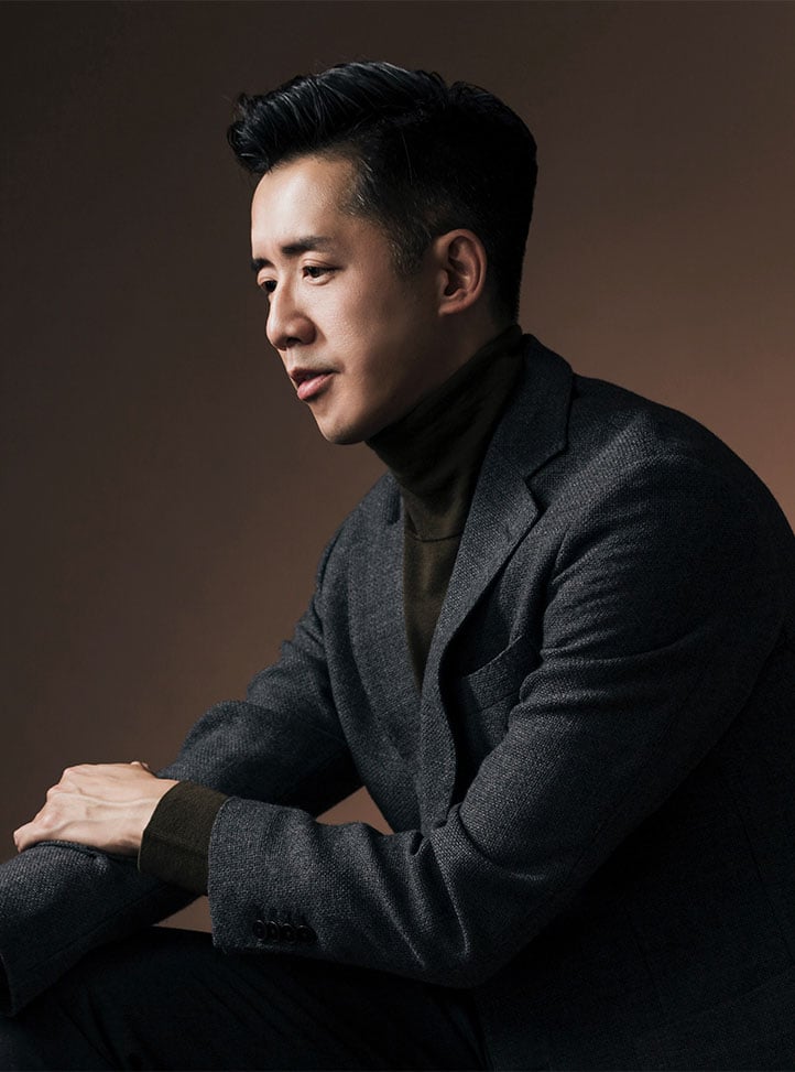 Professional portrait photograph of the side profile of Andre FUu in a dark blazer.