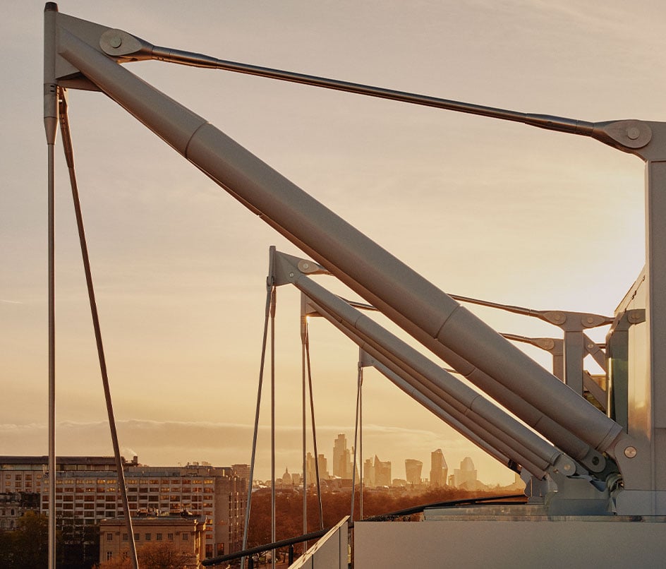 Architectural sails on The Emory's rooftop, with London's urban landscape in the background at sunset.